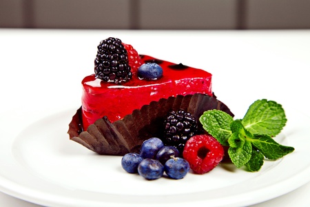 Little heart shaped cake with berries and mint on white backgroundの写真素材