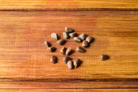 Some whole cedar nuts lying on wooden background.