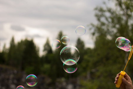 Human is blowing soap bubbles, they are up in the air.の写真素材