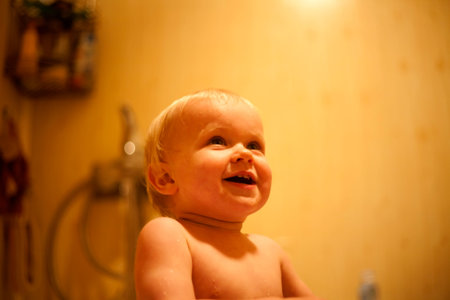 Portrait of amazed baby girl washing in bath.