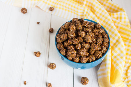 Chocolate caramel popcorn in cup on white wooden table. Horizontal photo. Sweet foodの写真素材
