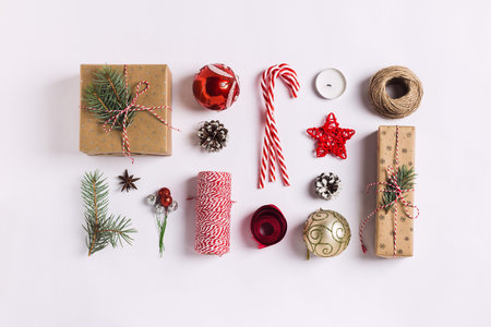 Christmas decoration composition gift box pine cones ball spruce branches candle ribbon candy cane on white festive table isolated. New year winter holiday xmas. Top view flat lay copy spaceの写真素材