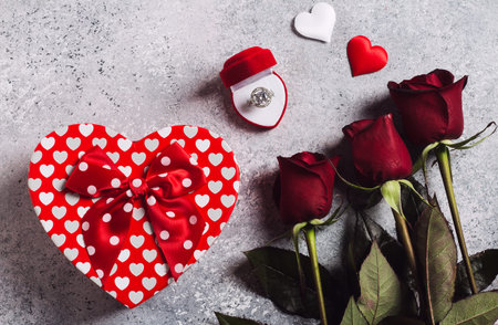 Valentines day marry me wedding engagement ring in box with red roses bouquet and gift box heart...