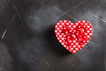 Valentines day womens mothers day gift box heart shape surprise on dark background. Love gift for woman on romantic holiday birthday weddingの写真素材