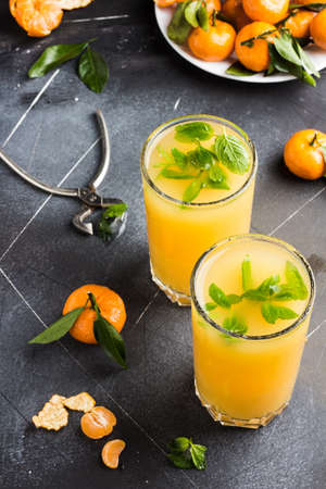Tangerine juice in glasses on light background. Orange mandarins sweet fresh citrus fruit healthy foodの写真素材