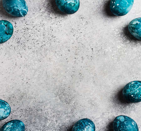 Easter eggs frame painted by hand in blue color on light background card with copyspace. Chicken eggs catholic and orthodox easter holidayの写真素材