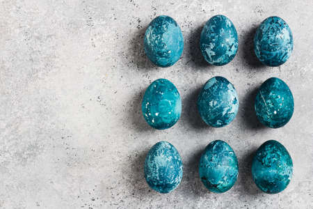 Easter eggs row painted by hand in blue color on light background. Chicken eggs catholic and orthodox easter holidayの写真素材