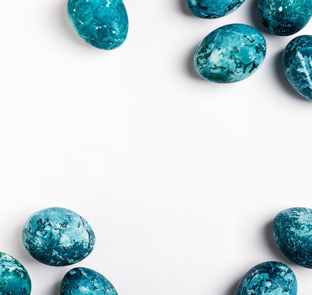 Easter eggs frame isolated painted by hand in blue color on white background card with copyspace. Chicken eggs catholic and orthodox easter holidayの写真素材