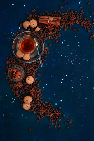 Coffee cup, chocolate chip cookies and scattered coffee beans. Creative top view hot drink concept with copy space. Ingredients for making coffee in a creative flat lay concept.の写真素材