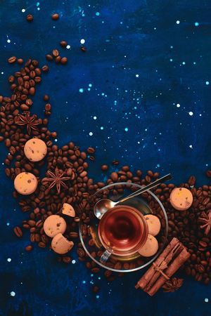 Coffee cup, chocolate chip cookies and scattered coffee beans. Creative top view hot drink concept with copy space. Ingredients for making coffee in a creative flat lay concept.の写真素材
