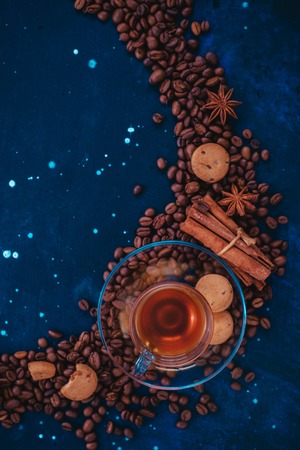 Coffee cup, chocolate chip cookies and scattered coffee beans. Creative top view hot drink concept with copy space. Ingredients for making coffee in a creative flat lay concept.の写真素材