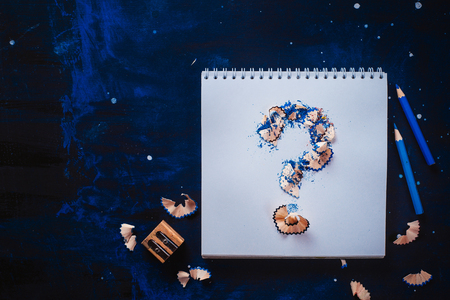 Question mark from pencil shavings with crumpled paper balls, pencils, notepads and empty coffee cups. Still life with writer workplace. Creative block concept.の写真素材