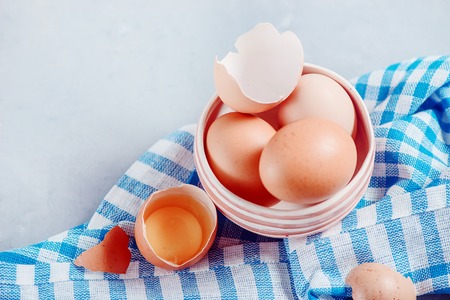 Brown eggs in a ceramic bowl close-up. Easter baking cocnept. High key background with copy space.の写真素材