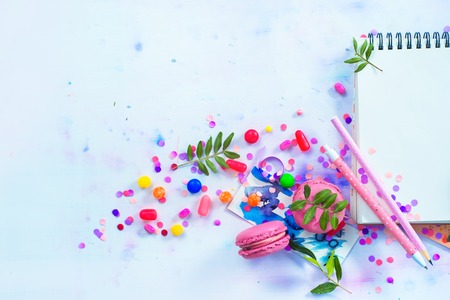 Party management and organization concept with sweets, confetti and an open notepad with blank pages. Creative celebration flat lay with copy space.の写真素材