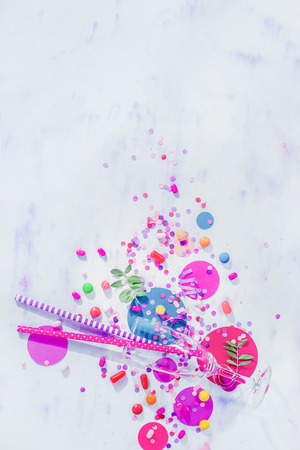 Champagne flute glass from above with straws, candies and confetti. Party concept with bar supplies, colorful flat lay with copy spaceの写真素材