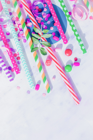 Cocktail straws, confetti and candies close-up in a colorful party supplies concept on a light background with copy space. Holiday accessoriesの写真素材