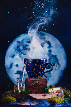 Ceramic cup with constellations in a witch or wizard workplace. Astronomy or astrology still life with Moon, crystals, moss and potion bottles. Magic concept with copy spaceの写真素材
