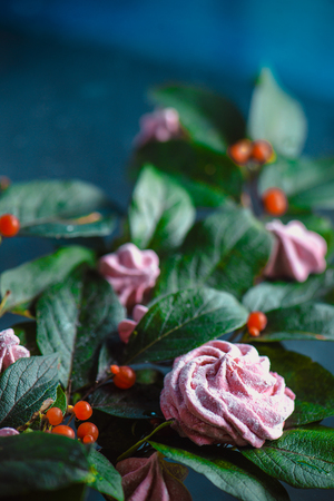 Meringues or marshmallow in a flower bouquet on a wooden clipboard. Floral arrangement in a modern dessert conceptの写真素材