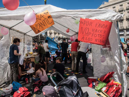 15M banners at the Puerta del Sol with protesters and backpacks. Madrid. Spainのeditorial素材