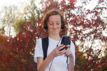 a teenager with a smartphone outdoors