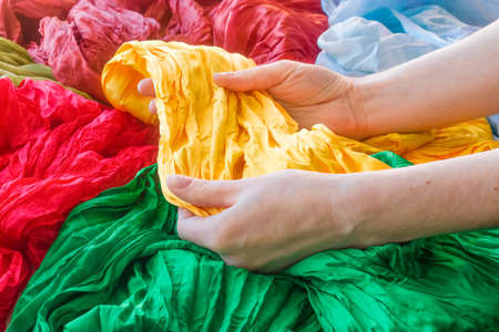 A woman chooses a silk scarfの写真素材