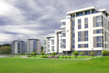 Modern urban architecture. A group of newly built houses. Residential complex. Realty. Dark clouds.