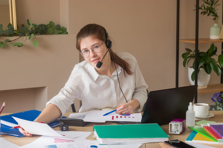 Work in the office. A young secretary girl 20-25 at her workplace.