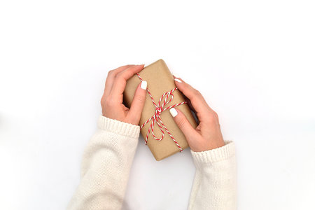 Woman hand are holding gift on the middle side on the wite background. Christmas and new year decoration.の写真素材