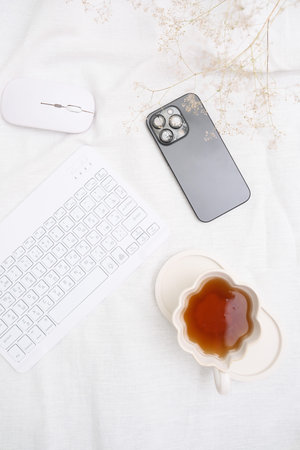 A Cozy and Inviting Workspace Featuring Tea, Technology, and Comfort for Productivityの写真素材