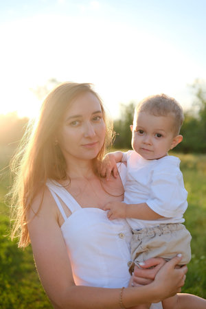 A portrait of a Mother and Child joyfully in a sunlit field, capturing their bondの写真素材