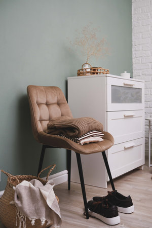 A stylish and cozy corner featuring a comfortable chair alongside essential clothing items