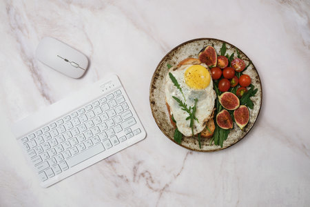 A delicious and healthy breakfast setup showcased on a stylish marble surface with technologyの写真素材