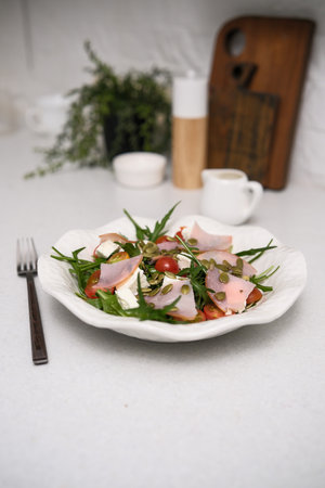 A Fresh Salad that Features a Medley of Greens and Various Vegetables Served on a White Plateの写真素材