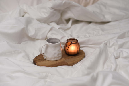 Wooden tray with coffee on the bed with white linenの写真素材