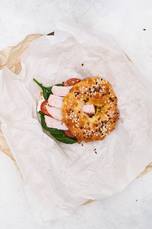 Breakfast bagels with ham, green on white parchment .の写真素材