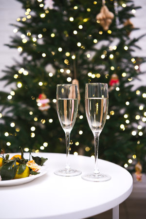 An Elegant Holiday Toast with Sparkling Champagne Enjoyed Near a Beautiful Christmas Treeの写真素材