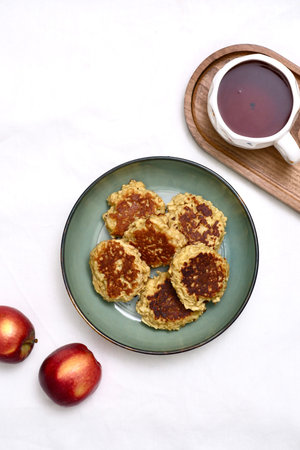Enjoying a Cozy Breakfast with Tea, Fresh Apples, and a Snack of apple pancakes on a Beautiful Wooden Trayの写真素材