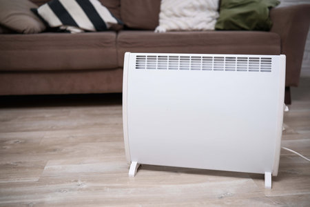 Modern Electric Heater Positioned in a Cozy Living Room Setting for Enhanced Comfort and Style.の写真素材