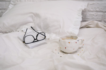 A warm and inviting composition that beautifully features a mug, various glasses, and soft white...