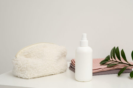 An aesthetically arrangement showcasing skincare products, white bottle, cosmetic bag and accessories ideal for beauty routines.の写真素材