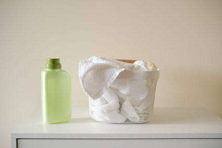Washing gel or laundry detergent near laundry basket with towels on white background. Mock up, copy space.の写真素材