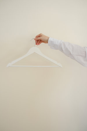 A Minimalist White Hanger Beautifully Displayed Against a Calm Neutral Wall Backgroundの写真素材
