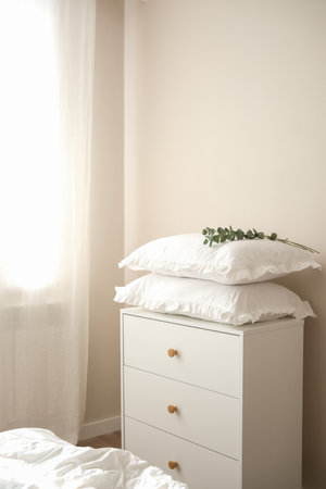 Two white pillows with leaves on bed on dresser.の写真素材