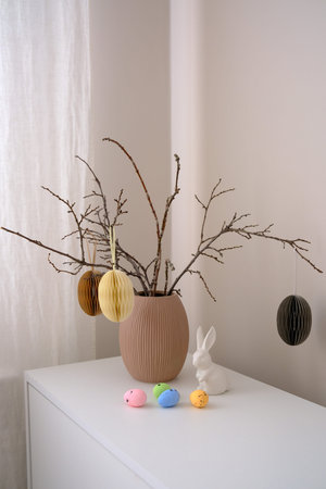 A beautifully minimalist springthemed decor that features elegant branches, easter craft eggs , a...
