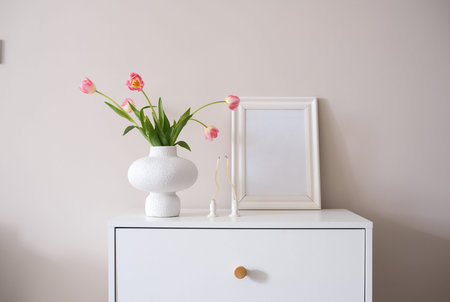 A serene, captivating display of beautiful pink tulips, arranged in a modern vase on a stylish...