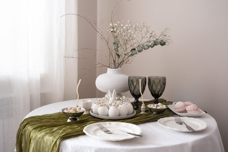 A beautifully arranged table with delicate flowers, desserts, and vintage glassware, creating a...
