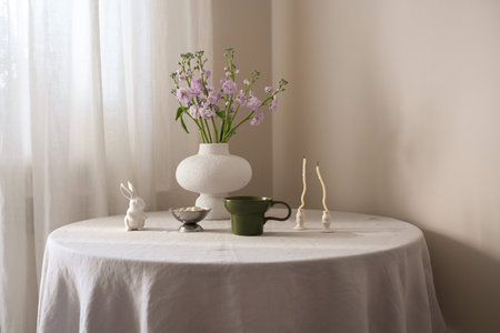 A beautifully serene table arrangement featuring vibrant flowers, elegant green cup of coffee,...