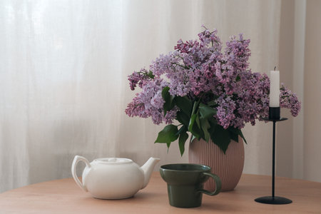 A Serene Still Life Composition Featuring Beautiful Lilac Flowers and an Elegant Teapotの写真素材
