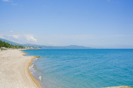 A Serene Beach Encompassing Crystal Clear Waters Combined with a Bright Blue Sky Aboveの写真素材