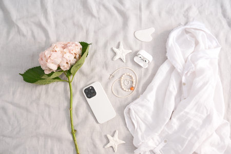 A Stylish Flat Lay Composition Featuring a Beautiful Mix of Floral and Tech Accessoriesの写真素材